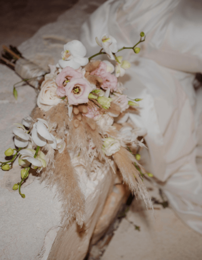 Elegant bridal bouquet with orchids and soft neutral blooms at a wedding in Croatia, placed beside the bride’s gown.