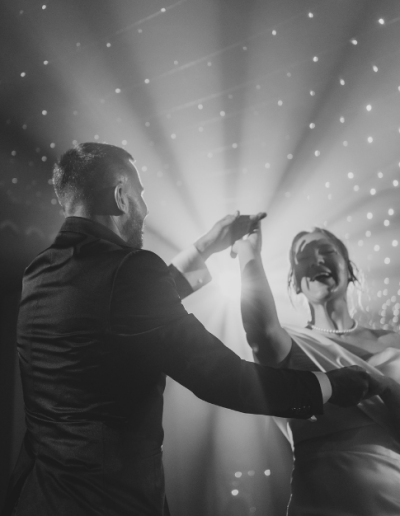 Bride and groom dancing under lights during their wedding in Croatia, captured in a joyful moment.